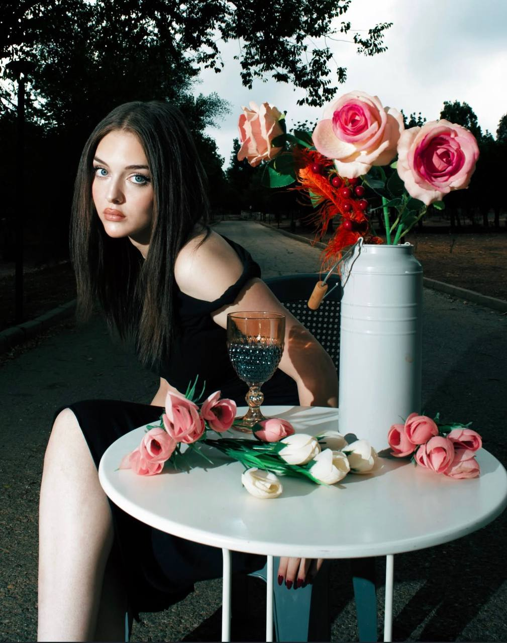 Roses on the table, and a gaze that holds the frame.